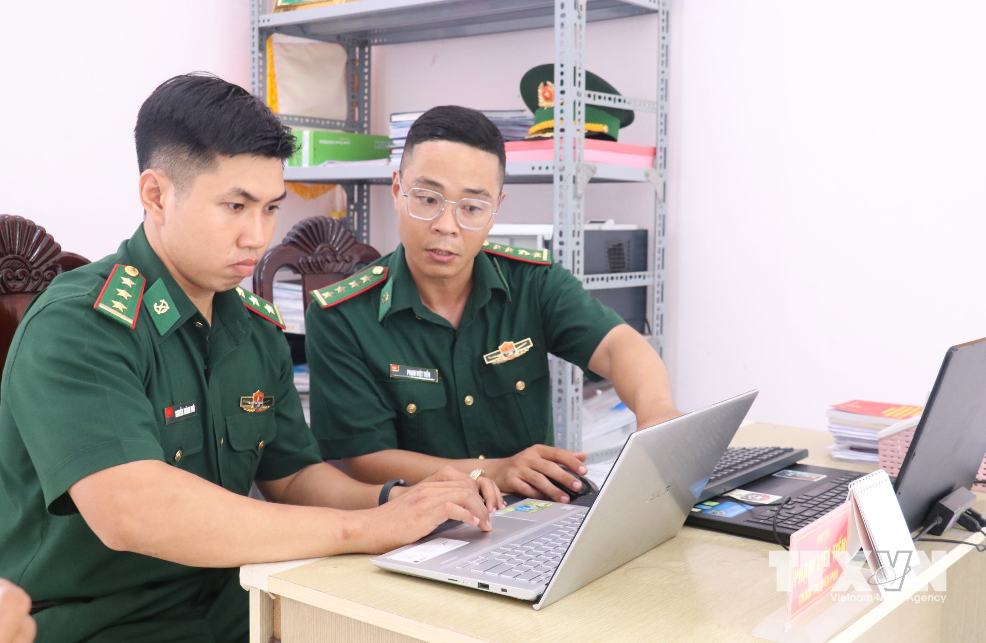 Đại úy Phạm Việt Tiến (đeo kính) cùng đồng đội nghiên cứu, chuẩn bị nội dung tuyên truyền, lựa chọn cách truyền đạt phù hợp với từng nhóm đối tượng trên địa bàn biên giới. (Ảnh: Bùi Giang/TTXVN)